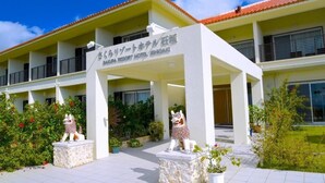 A hotel entrance with a sign, two lion statues, and a tiled pathway. - SAKURA RESORT HOTEL ISHIGAKI (Ishigaki)