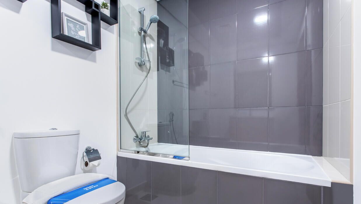 A modern bathroom with a toilet, a shower, and a bathtub.
