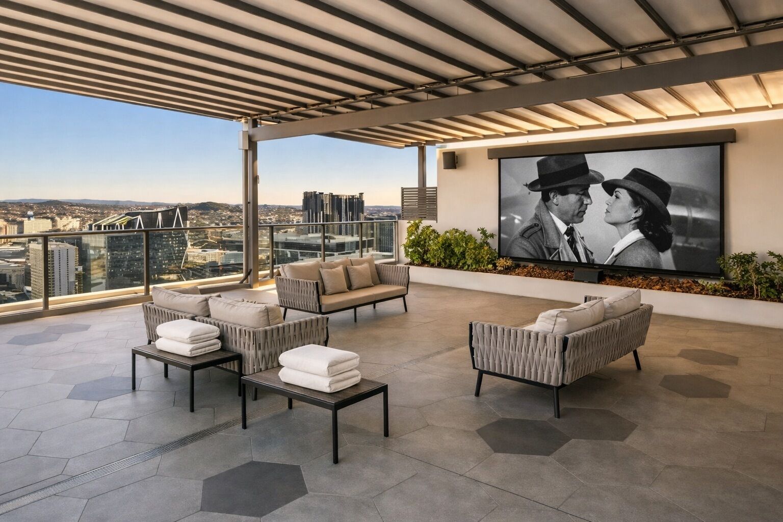 A rooftop terrace with a city view, a large flat-screen TV, and modern outdoor furniture.