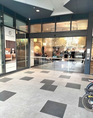 A hotel entrance with a glass door, a sign for Cdluxe Interior Australia, and a tiled floor. - Luxe-valley 2BR 2bath Infinity Pool (Brisbane)
