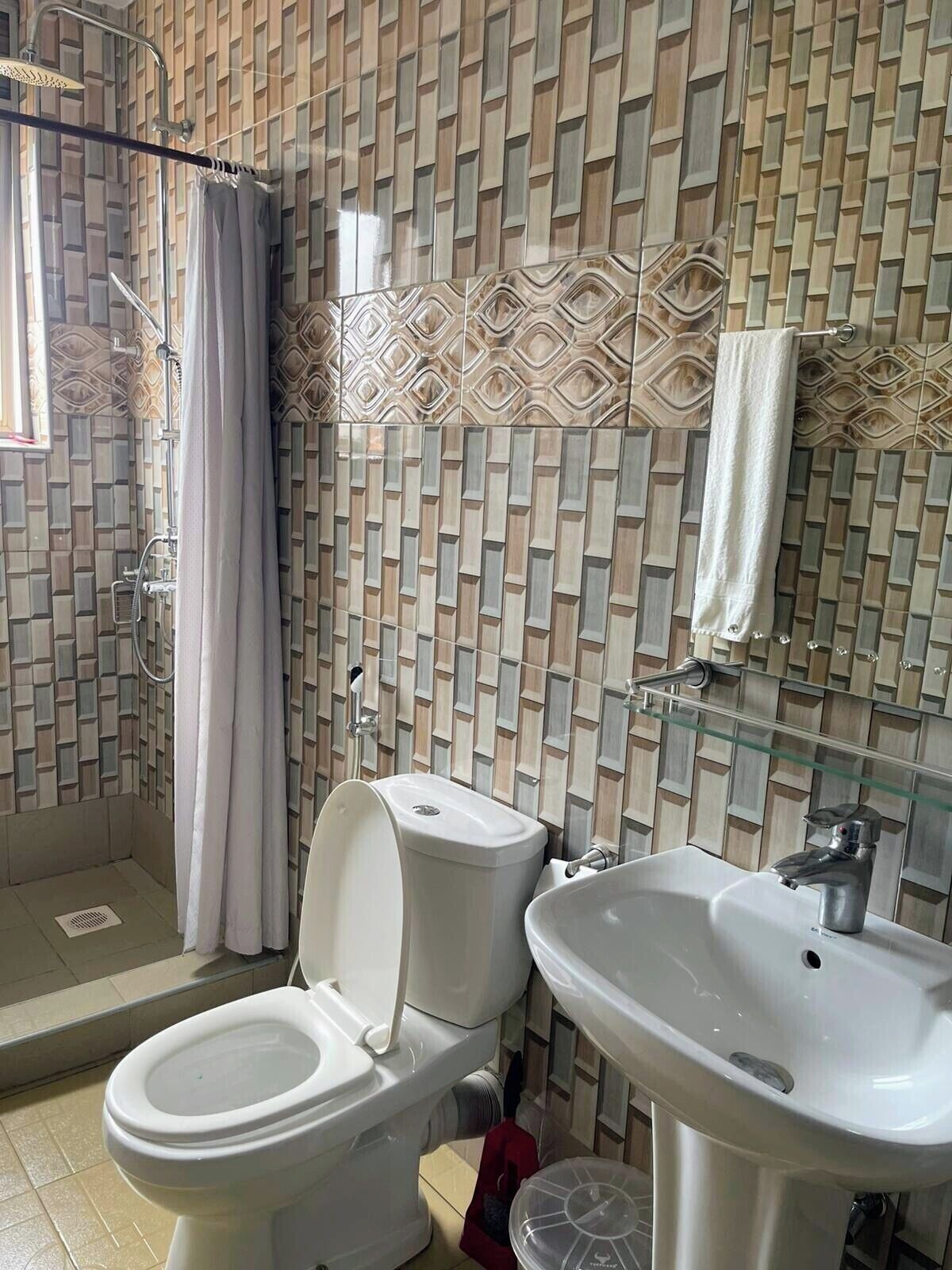 Ein Badezimmer mit Dusche, Toilette und Waschbecken.