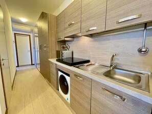 Eine moderne Küche mit integrierten Geräten, einer Edelstahl-Spüle und Holzkorpussen.