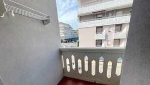 Un balcone con ringhiera bianca e vista sugli edifici vicini.
