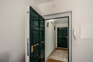 A hallway with a closed door, a light switch, and a telephone on the wall. - CS Spanish Steps Boutique B Apartment (Roma)