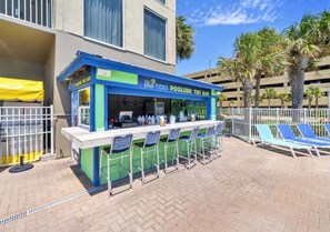 A poolside tiki bar with outdoor seating and a view of the pool area. - Gulf Dreams 1603-Gulf Front Resort-Sleeps 6 (Panama City Beach)