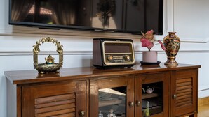 A wooden cabinet with a television, a radio, and decorative items. - Staymaster Shangrila-4BR Private villa  (Marra)