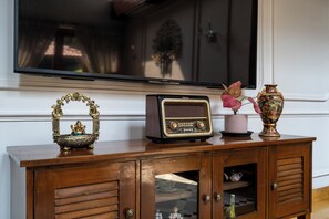 Un mueble de madera con un televisor, una radio y objetos decorativos.