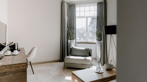 A modern, minimalist room with a desk, chair, and a small sofa.