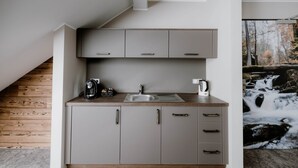 A modern kitchen with a built-in sink, a kettle, and a coffee maker. - StrandBerg's Designhotel Viktoria (Braunlage)