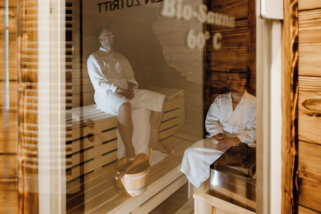 A sauna room with wooden benches and a glass door.