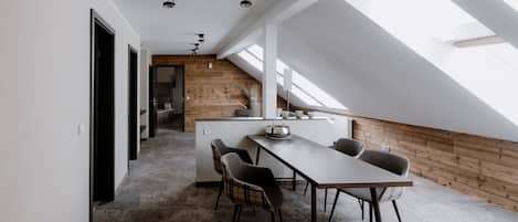 En modern loftlägenhet med matplats, trädetaljer och takfönster.