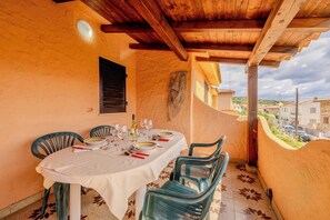 Ein Balkon mit Esstisch, Stühlen und Blick auf die Umgebung.