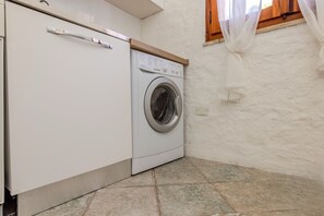 Ein kleiner Waschraum mit einer Waschmaschine mit Frontlader und einem Schrank.