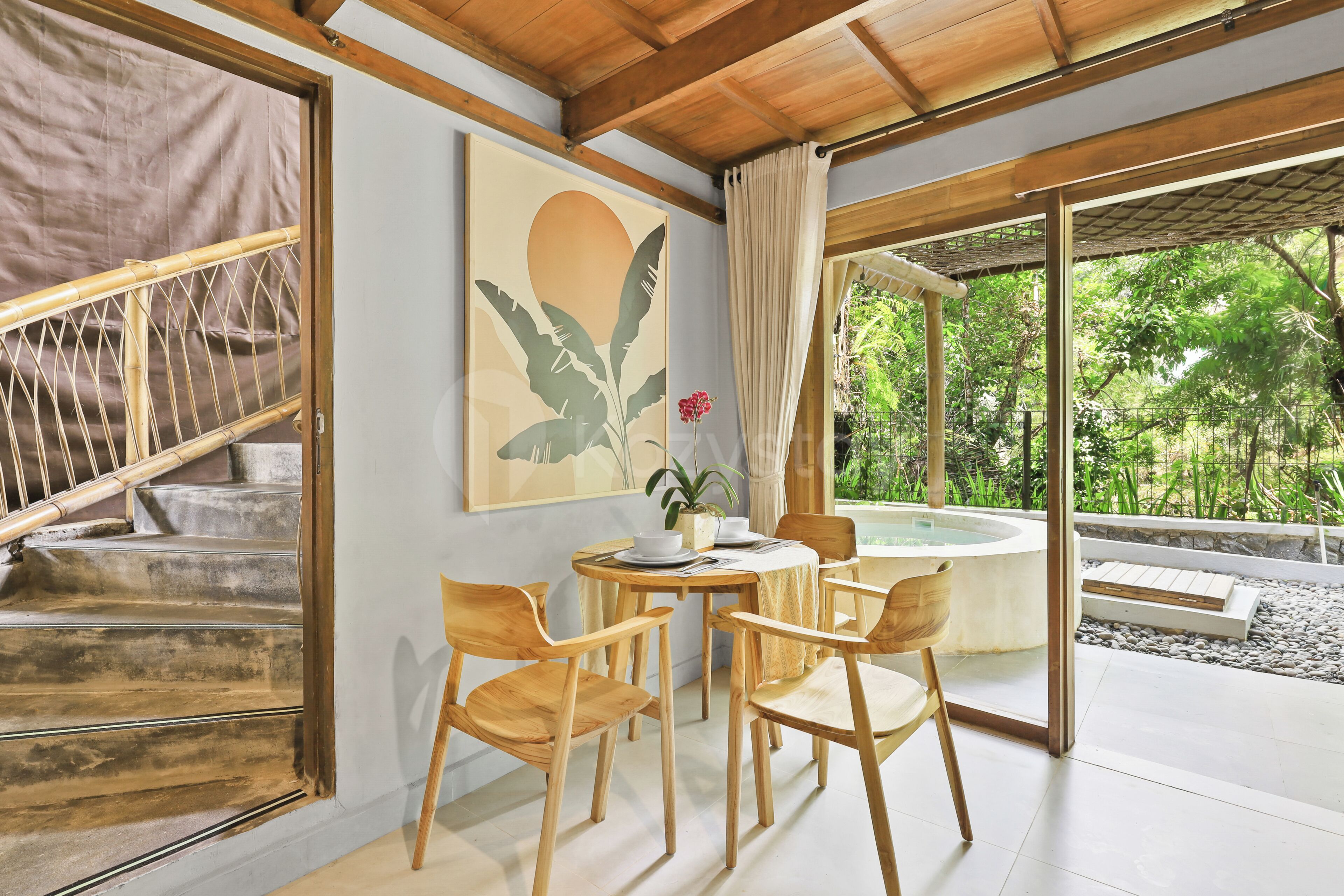 Quarto com uma mesa de jantar e cadeiras, um quadro e vista para o verde lá fora.