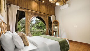 A room with a bed, a window with a view of greenery, and a wooden ceiling. - Sakara Bali Villa by Kozystay - Ubud (Kabupaten Gianyar)