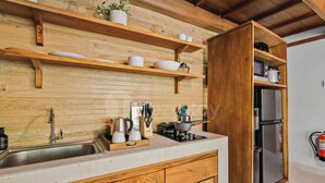 A kitchen with wooden cabinets, a stainless steel sink, a stove, and a refrigerator. - Sakara Bali Villa by Kozystay - Ubud (Kabupaten Gianyar)