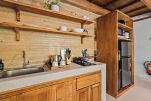 A kitchen with wooden cabinets, a stainless steel sink, a stove, and a refrigerator. - Sakara Bali Villa by Kozystay - Ubud (Kabupaten Gianyar)