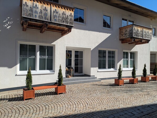 Ein Gebäude mit mehreren Fenstern und einem Balkon mit schmiedeeisernen Verzierungen.