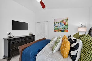 A bedroom with a bed, dresser, and a painting on the wall.