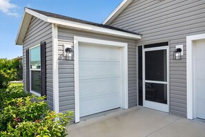 A residential garage with a white door and a garage door opener.
