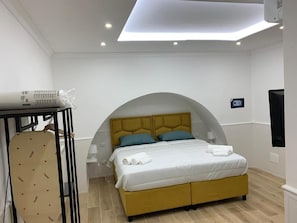 Un dormitorio con una cama, un escritorio y una silla.