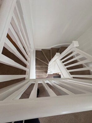 A spiral staircase with white railings and carpeted steps. - Under 10m to Airport/Hospital/Hydro/Breahead/City (Renfrew)