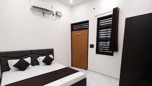 A bedroom with a bed, a wardrobe, a window with blinds, and an air conditioning unit. - Spacious 5-bedroom building in marvelous Mathura with AC (mathura)
