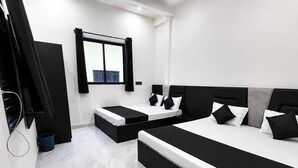 A modern bedroom with a large bed, a smaller bed, a TV, and a window with curtains. - Spacious 5-bedroom building in marvelous Mathura with AC (mathura)