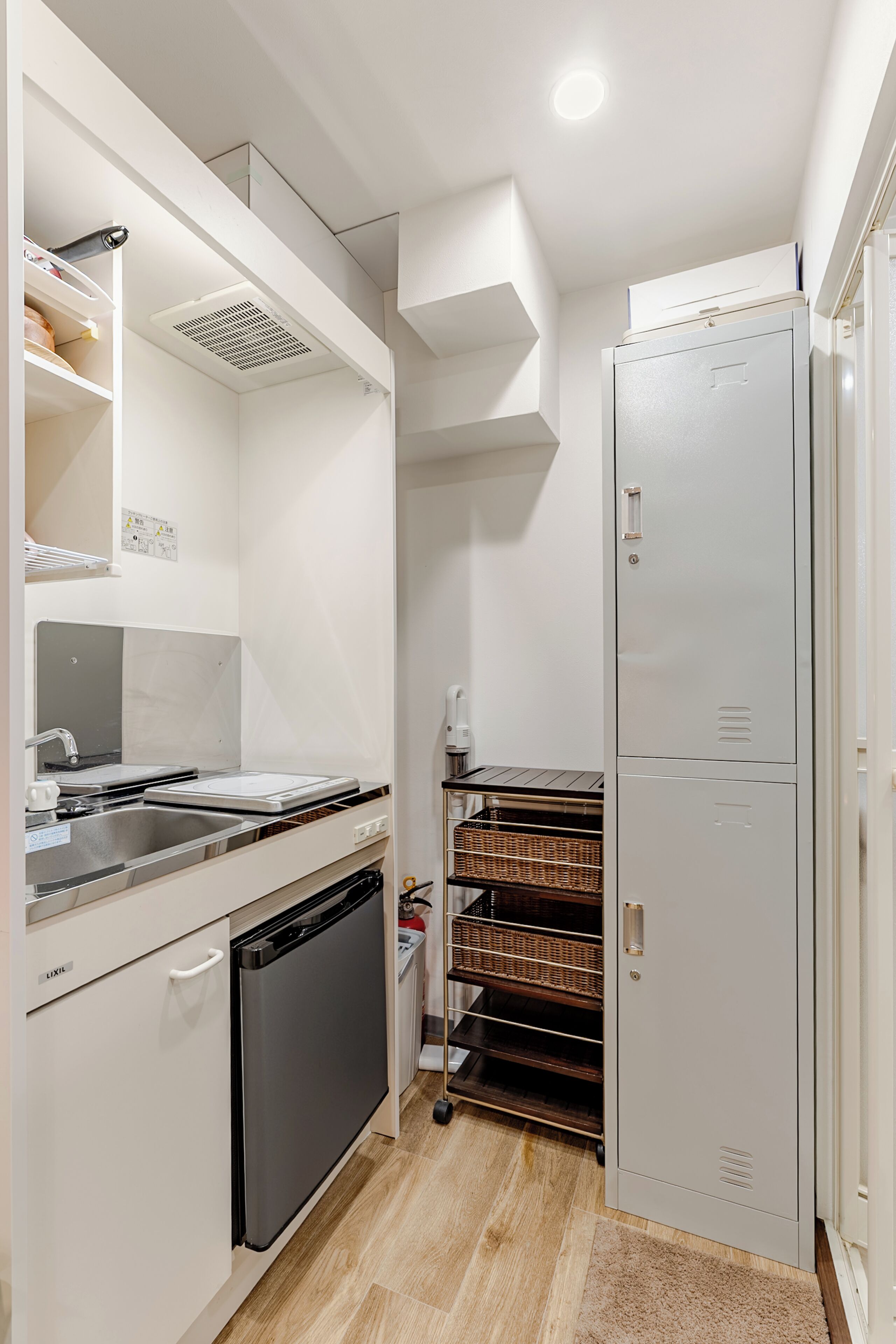 A compact kitchen with a dishwasher, a built-in oven, and a refrigerator.