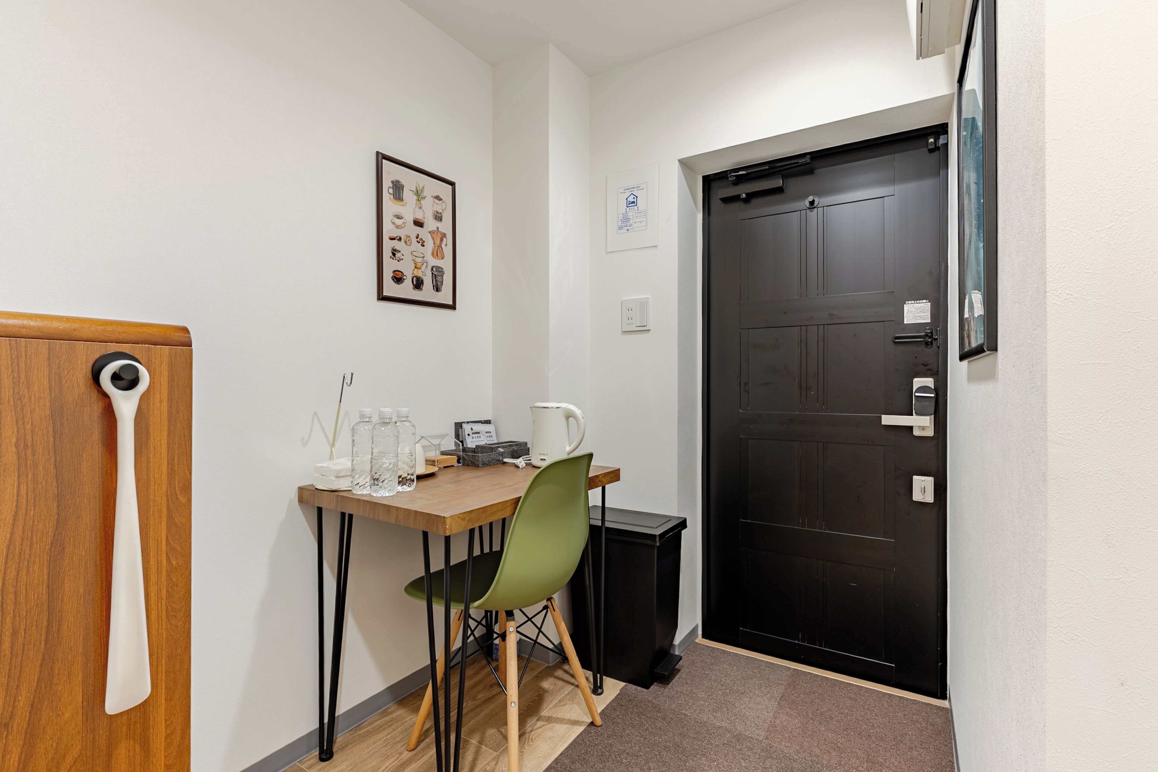 A small dining area with a table, chairs, a coffee maker, and a trash bin.