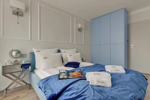 A hotel room with a bed, a side table, a globe, and a blue wardrobe. - Angielska Grobla 138B Atlantis | Near Old Town (Gdańsk)