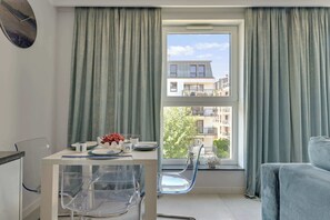A modern apartment with a dining area, a view of the city, and a balcony. - Angielska Grobla 138B Atlantis | Near Old Town (Gdańsk)