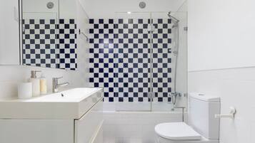 Ein modernes Badezimmer mit Wandgestaltung aus Schachbrettfliesen, einem weißen Waschbecken und einer Toilette.