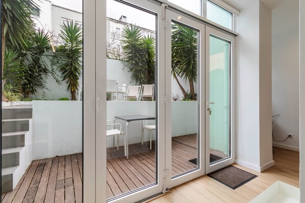 A modern interior with a sliding glass door leading to an outdoor patio area. - Garden Terrace - Lisbon City Retreat (Lisboa)