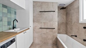 Ein modernes Badezimmer mit Dusche, Waschbecken und Toilette.