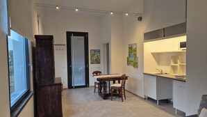 Un intérieur moderne comprenant un coin repas, une cuisine et une grande fenêtre.