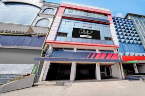 A modern building with a prominent 'Collection' sign, large windows, and a red and white facade.