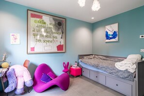 Ein Schlafzimmer mit einem Bett, einem Schreibtisch, einem Stuhl und einer Wand mit einem gerahmten Zitat.