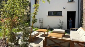 Un área de estar al aire libre con muebles de madera y una planta en maceta.