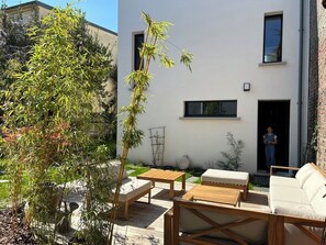 Ein Sitzbereich im Freien mit Holzmöbeln und einem Blumentopf.