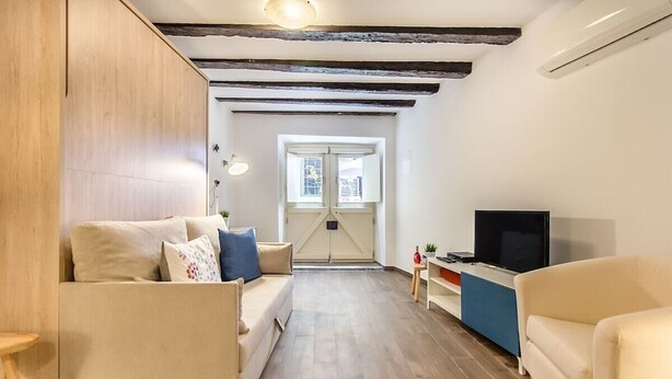 Een moderne woonkamer met een bank, een televisie en een kleine tafel.