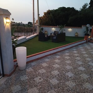 A rooftop terrace with a seating area, artificial grass, and a decorative wall. - Villa ROSALIA with a Jacuzzi, Barbecue, and Sunset View (Tonnara di Bonagia)