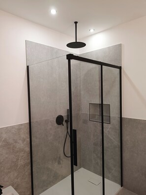 A modern shower enclosure with a glass door, a black frame, and a ceiling-mounted showerhead. - Villa ROSALIA with a Jacuzzi, Barbecue, and Sunset View (Tonnara di Bonagia)