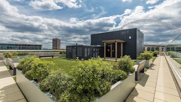 Un edificio moderno con tetto piatto, circondato da un giardino curato e un percorso pedonale.