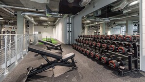 A gym with weightlifting equipment and a bench. - Landsby (Wembley)
