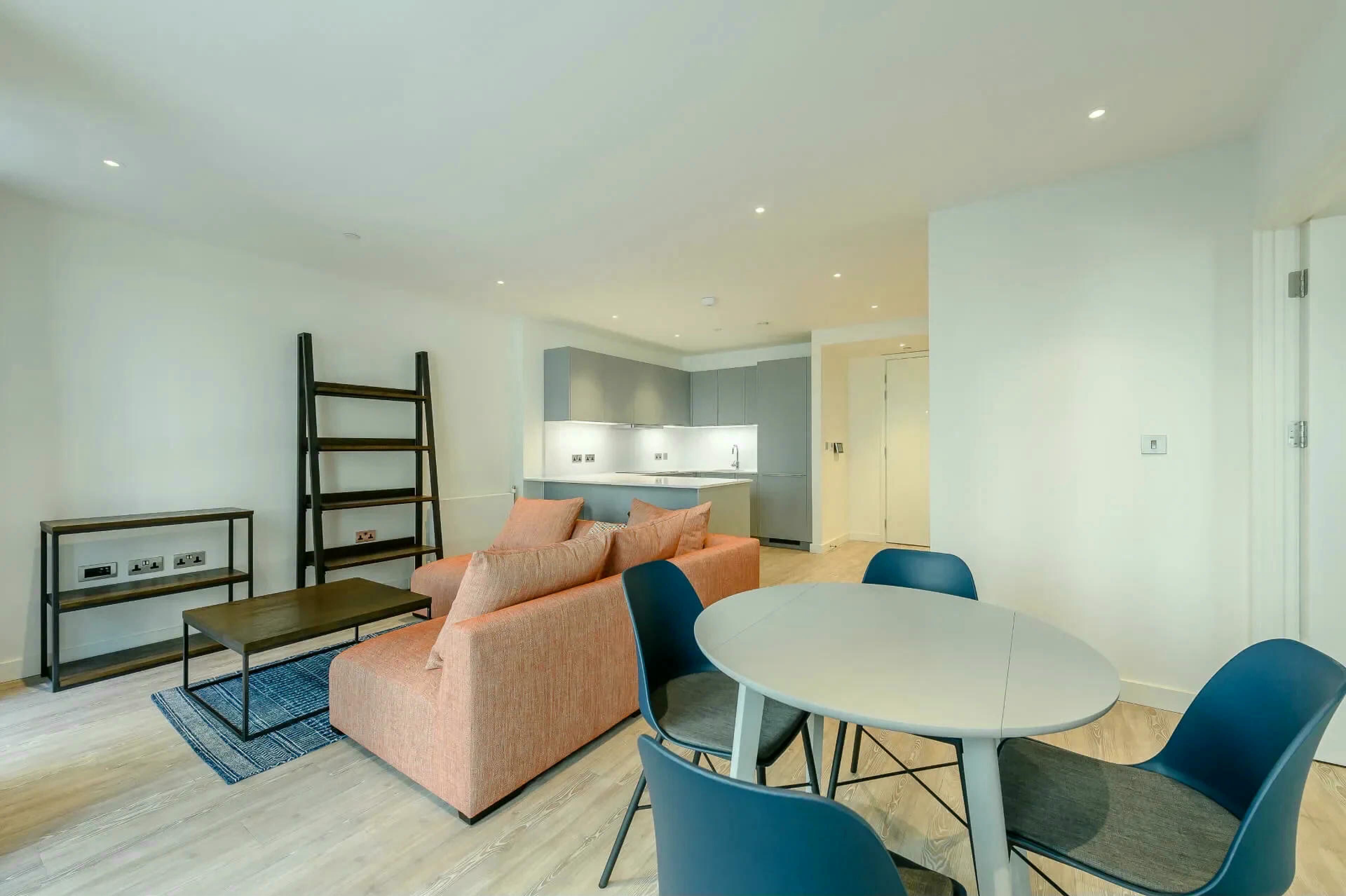 Ein stilvolles Wohnzimmer mit einer Couch, einem Couchtisch und einem Essbereich mit Stühlen.