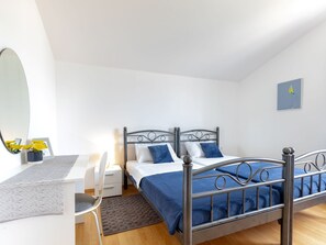 Un dormitorio con dos camas, un escritorio y una silla.