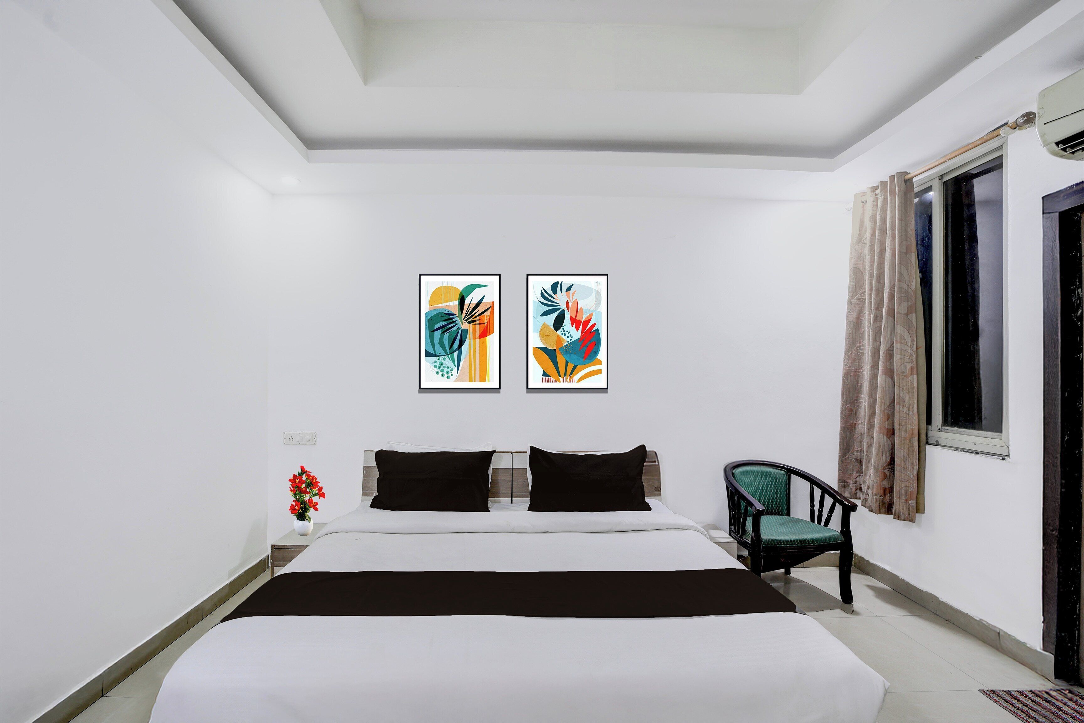 Ein Hotelzimmer mit einem Bett, zwei Bildern an der Wand, einem Sessel und einem fenster mit Vorhängen.