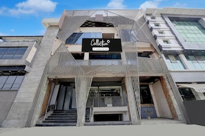 Un bâtiment moderne, facilement reconnaissable grâce à une grande enseigne indiquant « Collection », doté d’une façade géométrique et d’un escalier menant à l’entrée.