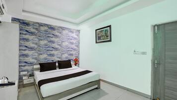 A bedroom with a bed, a wall with a marble-like texture, a door, and a framed picture on the wall.